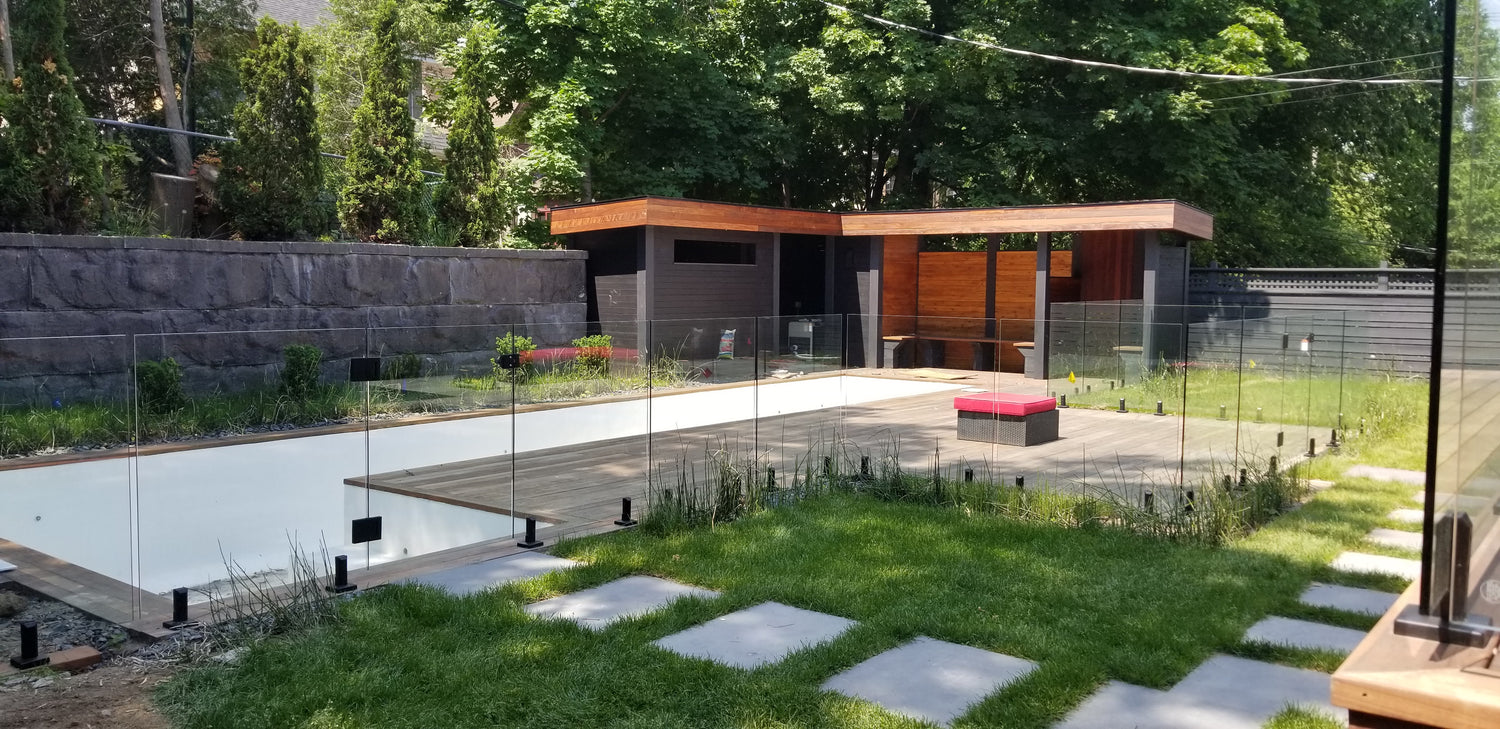 Clôture de piscine en verre trempé sur bois à Montréal avec une porte hydraulique et paysagement