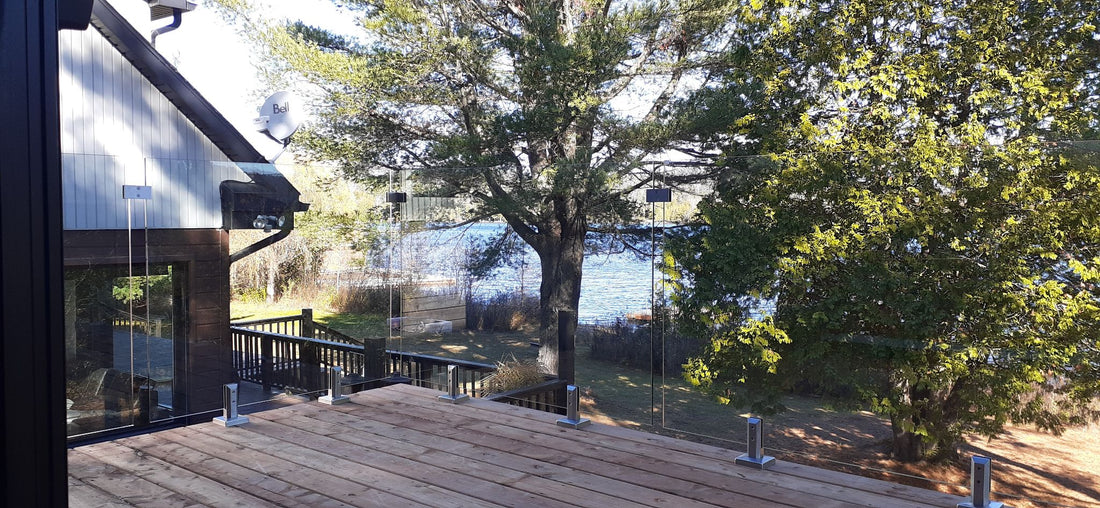 Rampe de verre sur balcon de bois près d'un lac